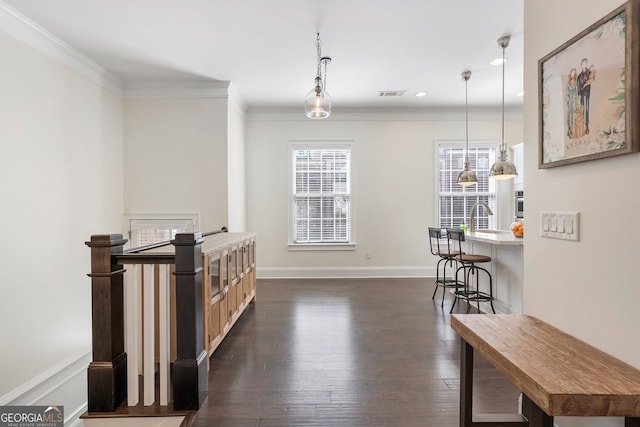 hall featuring baseboards, visible vents, dark wood finished floors, ornamental molding, and recessed lighting