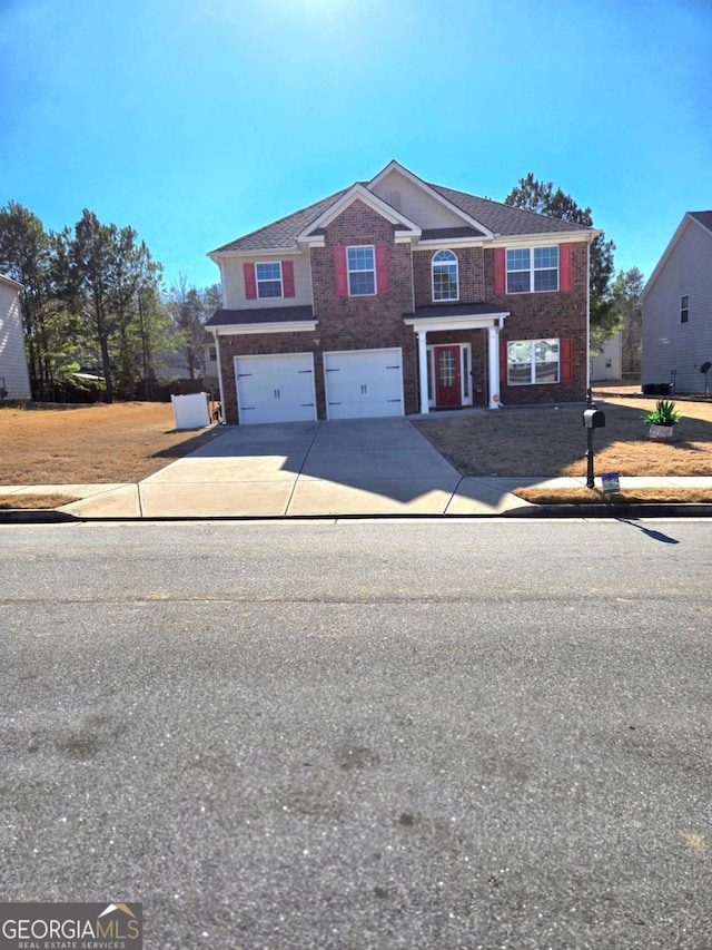 traditional home featuring a garage, driveway, and brick siding