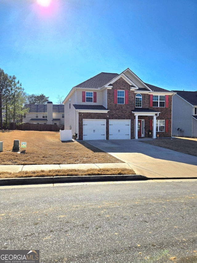 view of front of home with driveway, an attached garage, and brick siding