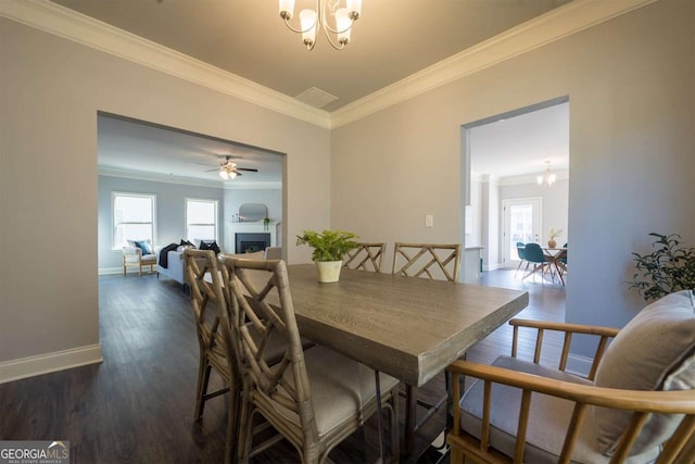 dining area with plenty of natural light, a fireplace, crown molding, and dark wood-type flooring