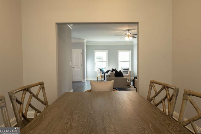 dining room featuring a ceiling fan, crown molding, and baseboards