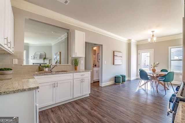 kitchen with pendant lighting, white cabinets, and a sink