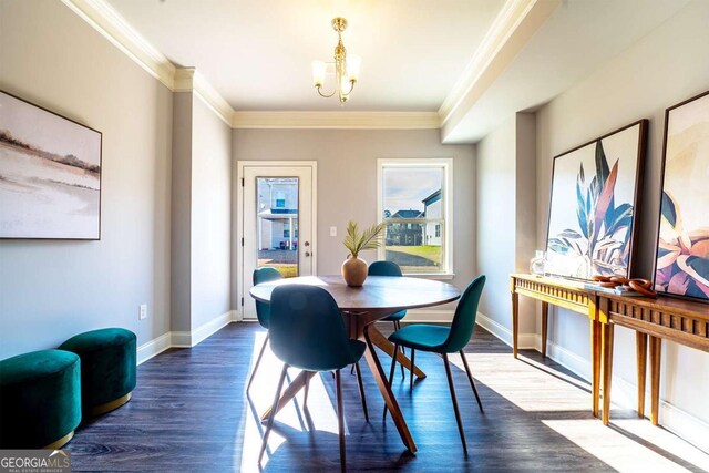 dining room with dark wood-style floors, an inviting chandelier, baseboards, and crown molding