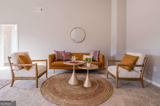 sitting room with baseboards, visible vents, and light colored carpet