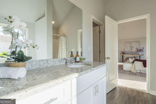 ensuite bathroom with curtained shower, ensuite bath, wood finished floors, and vanity