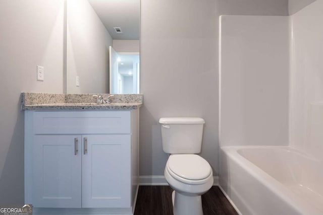 bathroom featuring baseboards, visible vents, toilet, wood finished floors, and vanity