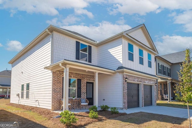 traditional-style home with a garage, covered porch, brick siding, and concrete driveway