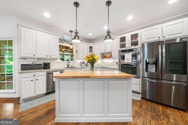 kitchen featuring appliances with stainless steel finishes, a center island, white cabinetry, and wooden counters