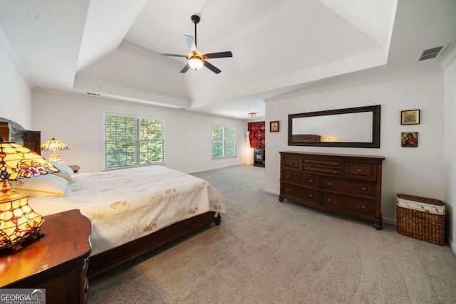 bedroom with a ceiling fan, a raised ceiling, visible vents, and light colored carpet