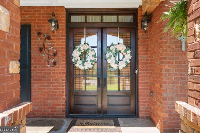 entrance to property featuring french doors and brick siding