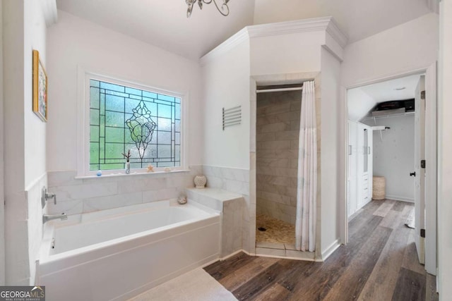 bathroom featuring a shower stall, a bath, and wood finished floors