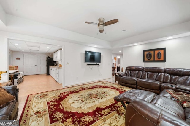 living area with light wood-style floors, baseboards, a ceiling fan, and recessed lighting