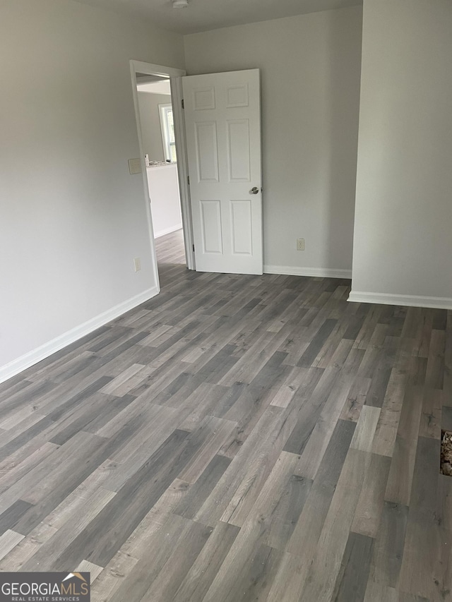 unfurnished room with baseboards and wood finished floors