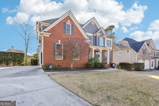 traditional-style house featuring a front lawn, a porch, and brick siding