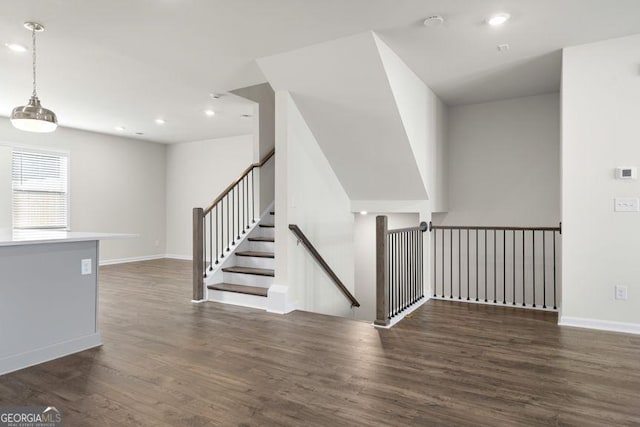 stairway with baseboards, wood finished floors, and recessed lighting