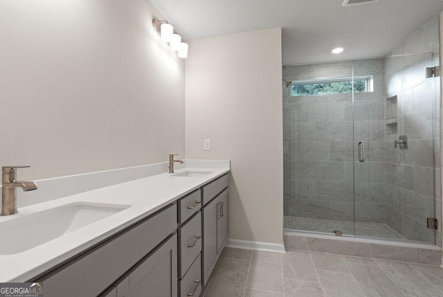 bathroom with baseboards, double vanity, a sink, and a shower stall