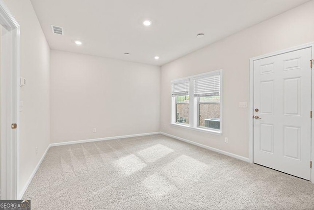 spare room featuring baseboards, recessed lighting, visible vents, and light colored carpet