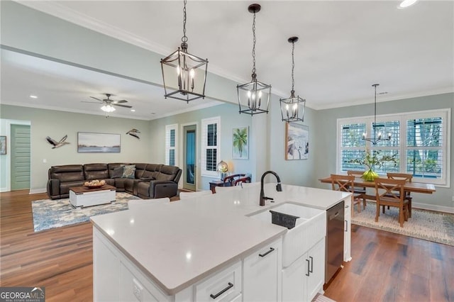 kitchen featuring an island with sink, open floor plan, and hanging light fixtures