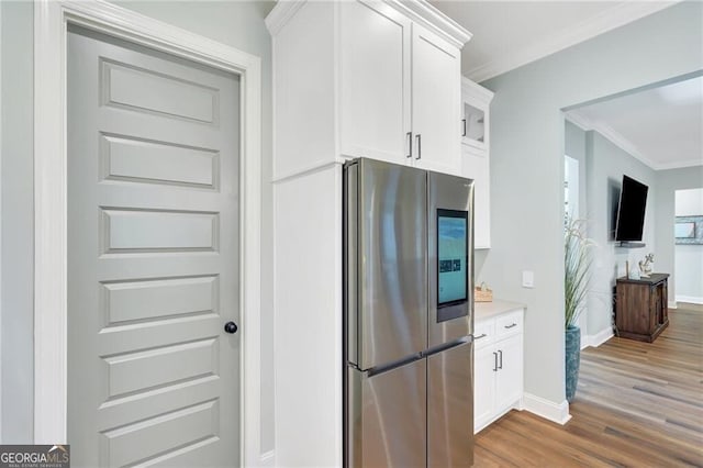 kitchen featuring ornamental molding, light countertops, smart refrigerator, and white cabinetry