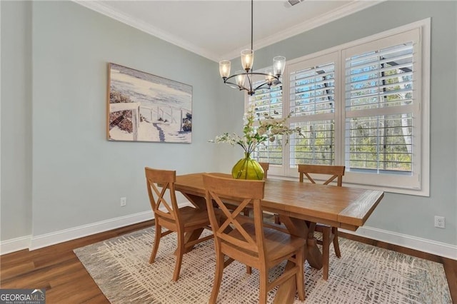 dining room featuring ornamental molding, a chandelier, baseboards, and wood finished floors