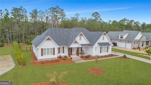 modern farmhouse style home with fence, a front lawn, and concrete driveway