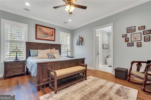 bedroom with ornamental molding, wood finished floors, and visible vents