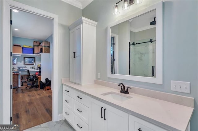 bathroom featuring marble finish floor, vanity, crown molding, and a stall shower