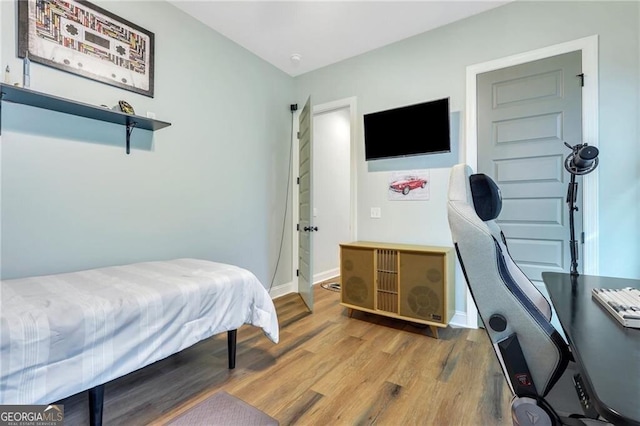 bedroom featuring baseboards and wood finished floors