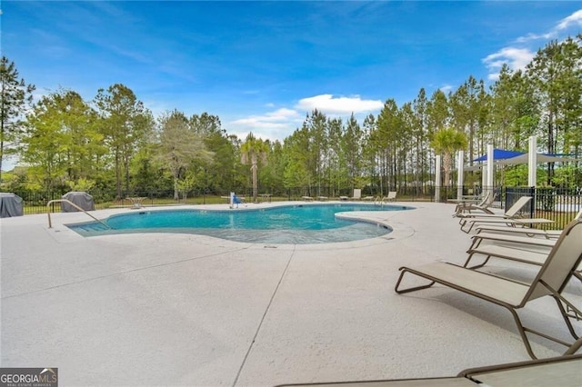 community pool featuring a patio and fence