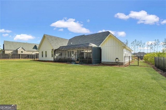 back of house featuring glass enclosure, a fenced backyard, and a lawn