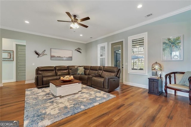 living area featuring ornamental molding, wood finished floors, and visible vents