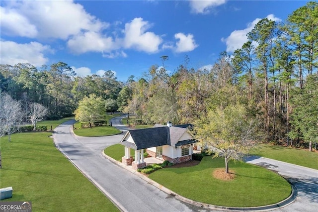 surrounding community featuring a yard and aphalt driveway