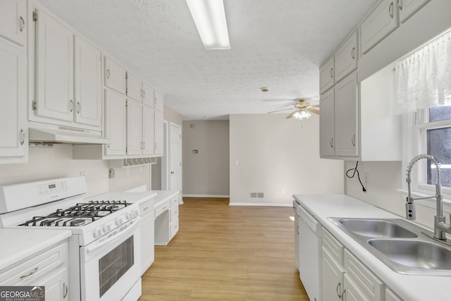 kitchen with light countertops, white cabinets, a sink, white appliances, and under cabinet range hood