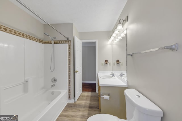 full bathroom featuring shower / bathtub combination, toilet, a textured ceiling, vanity, and wood finished floors