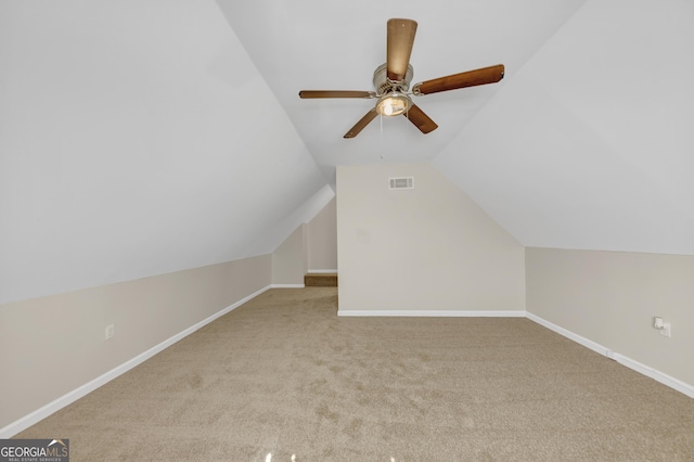 bonus room featuring lofted ceiling, light carpet, a ceiling fan, and baseboards