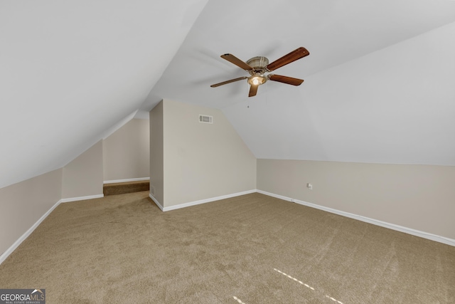 additional living space with lofted ceiling, ceiling fan, carpet floors, visible vents, and baseboards