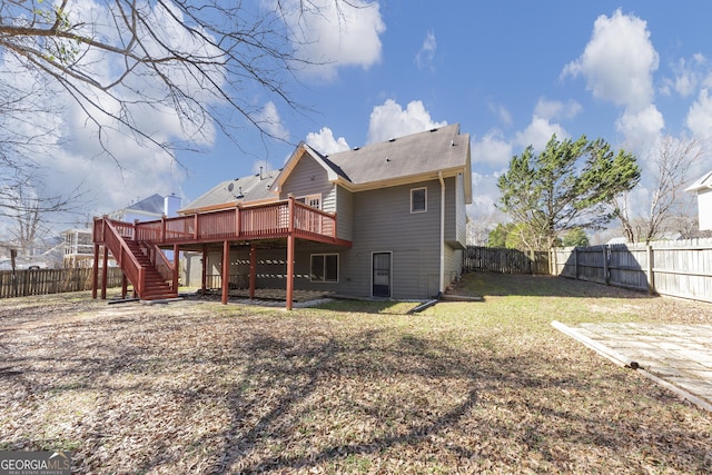 back of property with a fenced backyard, a lawn, a deck, and stairs