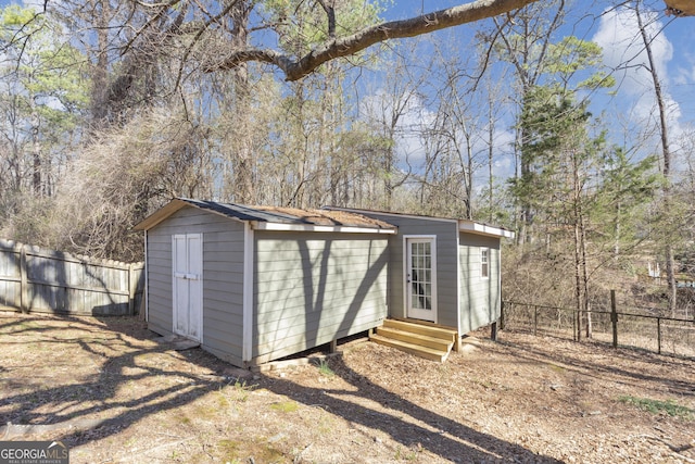 view of outdoor structure featuring entry steps and a fenced backyard