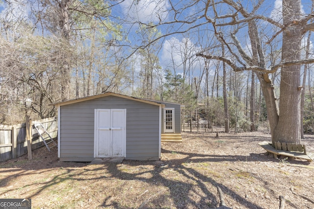 view of shed with entry steps and fence