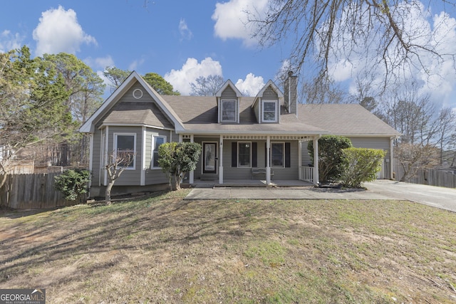 view of front of house featuring fence, a front lawn, a porch, and concrete driveway