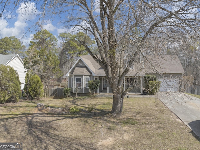 view of front of property with driveway, an attached garage, fence, and a front yard