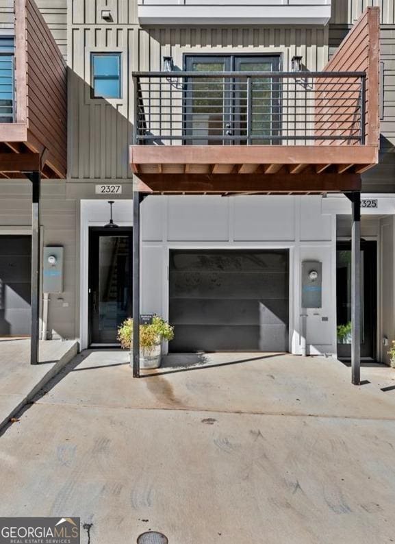 exterior space featuring driveway, a balcony, a garage, and board and batten siding