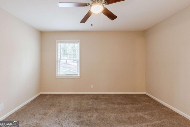 carpeted empty room featuring baseboards and a ceiling fan