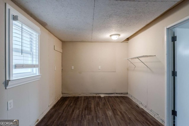 laundry room with dark wood-style flooring and a textured ceiling