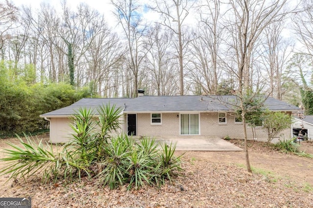 rear view of property featuring a patio area and brick siding