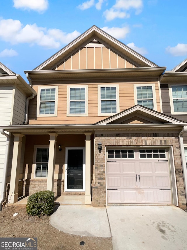 townhome / multi-family property with board and batten siding, concrete driveway, a porch, and an attached garage