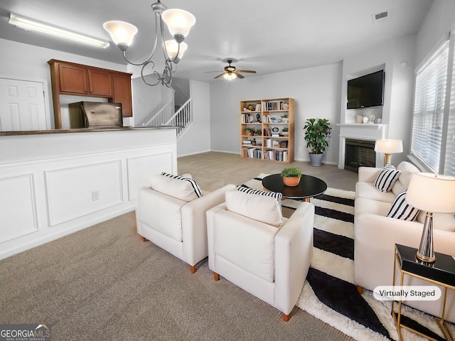 living room featuring light carpet, stairway, a fireplace, and visible vents