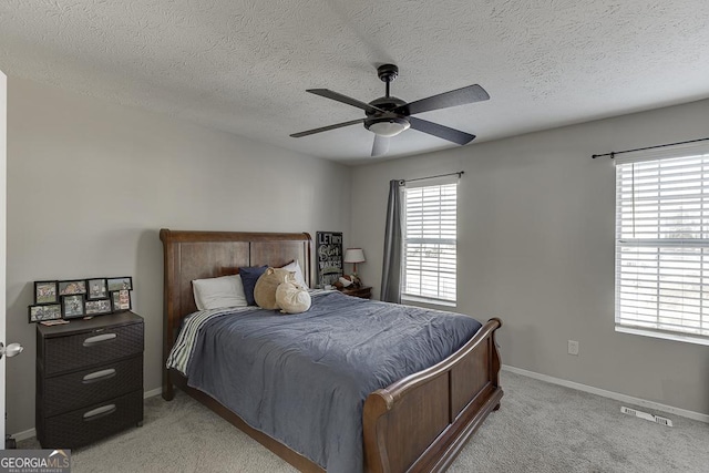 bedroom with light carpet, multiple windows, visible vents, and baseboards