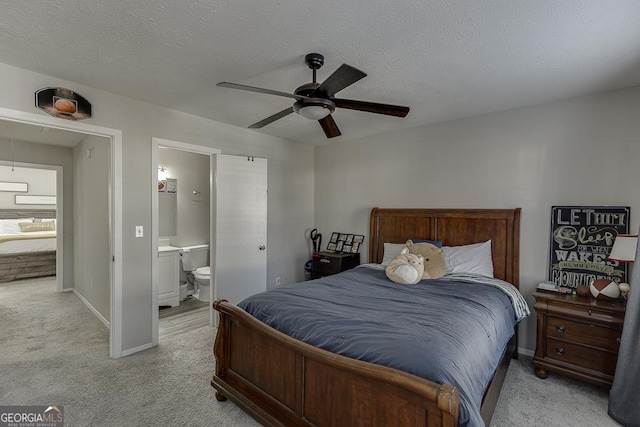 bedroom with baseboards, light colored carpet, ceiling fan, ensuite bathroom, and a textured ceiling