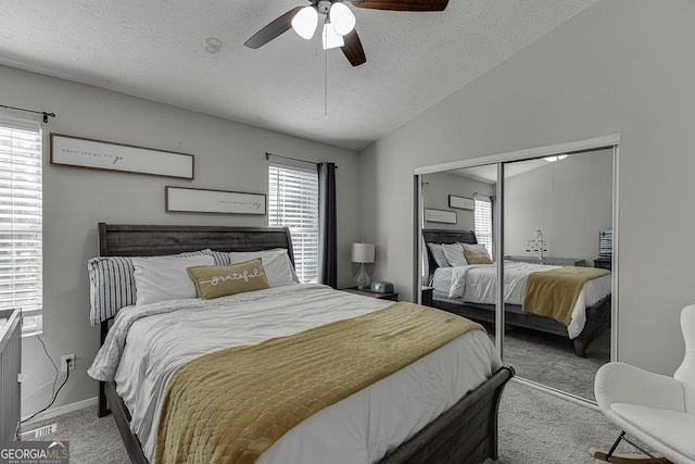 bedroom with lofted ceiling, a closet, light colored carpet, and multiple windows